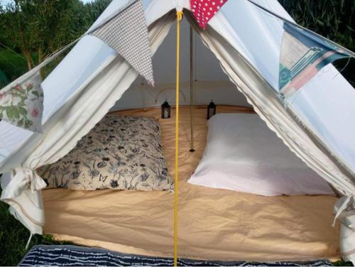 Tienda con cama en el medio en Campsite with Gypsy Vardo Bell Tent, en Loré