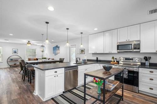 a large kitchen with white cabinets and a table at Downtown St Aug Home by Fountain of Youth Pool Spa by Beach Add Golf Cart in St. Augustine