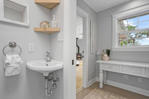 a white bathroom with a sink and a window at Onyx House King Size Beds Bikes Games Wine in St. Augustine