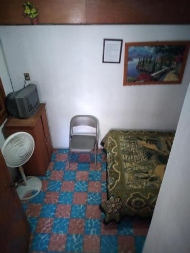 a small room with a bed and a tv at Hotel Las Palomas in Taxco de Alarcón