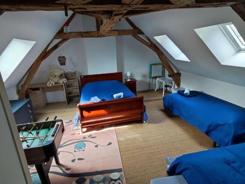 Habitación en el ático con 2 camas y mesa en Gîte de la vallée à Courdemanche Sarthe en Courdemanche