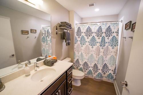 a bathroom with a sink and a shower curtain at Luxury King Bed Apt in Downtown GR in Grand Rapids