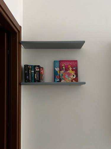 a book shelf with two books on it at Mary T House in Campagnano di Roma