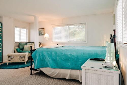 a bedroom with a blue bed and a chair at Beach Club of Oscoda Captains Watch on the Lake in Oscoda