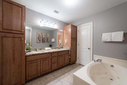 a bathroom with a tub and a large sink at Phoenix West II 2307 Lazy River + Waterslide in Orange Beach