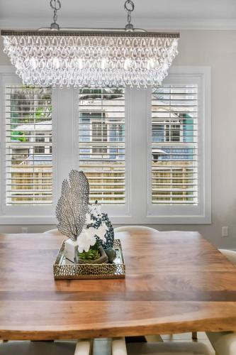 a dining room with a wooden table and a chandelier at Steps to Ice Plant in Historic St Aug Upscale in St. Augustine