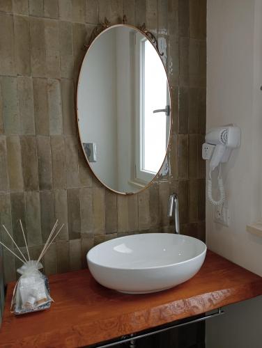 a bathroom with a white sink and a mirror at Vicol8Netino in Noto