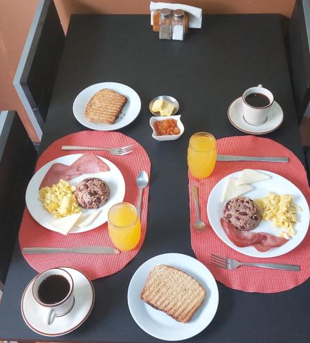 モンテベルデ・コスタリカにあるHotel las Ardillas Monteverdeの朝食の食べ物と飲み物の皿が置かれたテーブル