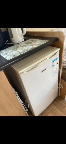 a white appliance sitting under a counter top at 2-Bed Caravan in Mablethorpe sea front location in Mablethorpe