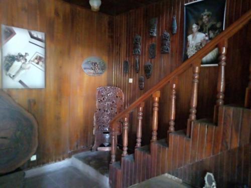 una escalera con una pared de madera con cuadros. en Maliga inn en Gampola