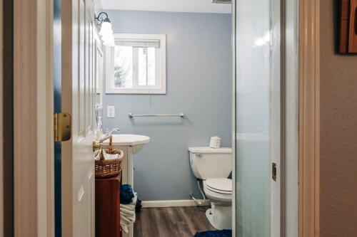 uma casa de banho com um WC, um lavatório e uma janela em Beach Club of Oscoda Garden Cottage on the Lake em Oscoda