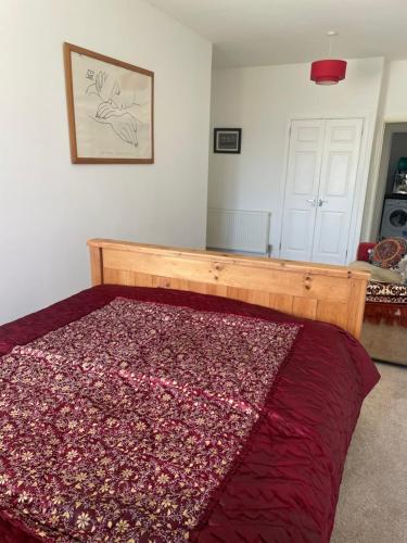 a bedroom with a bed with a red blanket on it at Homestay in Glasgow