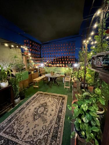 a room filled with lots of plants and a rug at Anavrin Art House in New Delhi