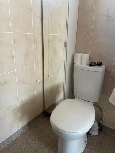 a bathroom with a toilet with a pair of glasses on it at Homestay in Glasgow