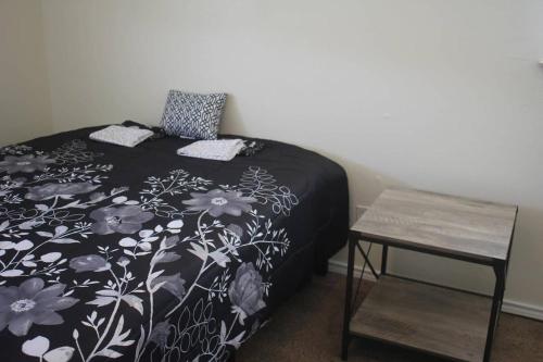 ein Schlafzimmer mit einem Bett mit einer schwarzen und weißen Decke in der Unterkunft 1 bedroom apartment within sight of Fort. Sill in Lawton
