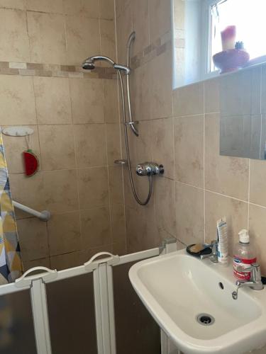 uma casa de banho com um lavatório e um chuveiro em Homestay em Glasgow