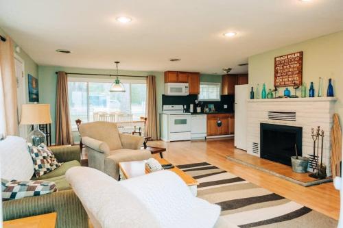 un soggiorno con divano e camino di Beach Club of Oscoda - The Lakeshore Cottage a Oscoda