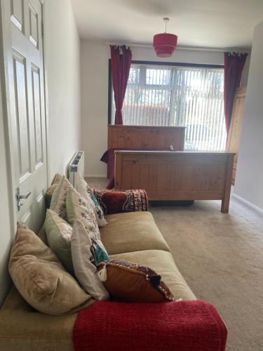 a living room with a couch with pillows on it at Homestay in Glasgow