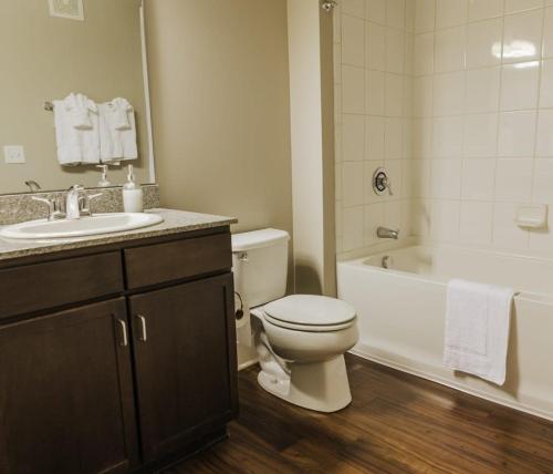 a bathroom with a toilet and a tub and a sink at 2BR Balcony Suite Gym & Pool Downtown at CityWay in Indianapolis