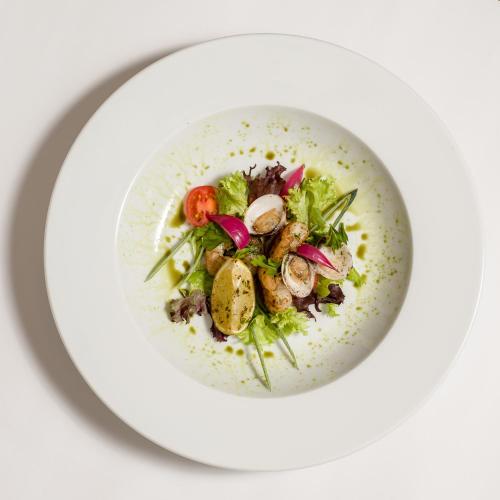 a white bowl of food on a white plate at Hotel Piroska in Bük