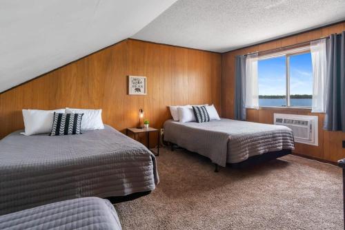 a hotel room with two beds and a window at Fife Lake Lodge Multi-level Suite with Lake Views in Fife Lake