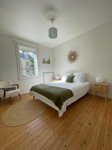 une chambre blanche avec un lit et une fenêtre dans l'établissement Villa Blanche, à Agon-Coutainville