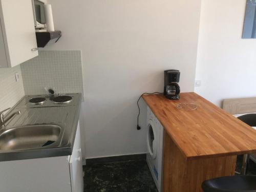 une petite cuisine avec un évier et une machine à laver dans l'établissement Cannes center AC Wi-fi terrace 200 m sea Croisette, à Cannes