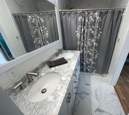 uma casa de banho com 2 lavatórios e um espelho grande em Downtown Rockford Duplex em Rockford