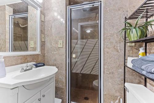 y baño con ducha y lavamanos. en Charming 2BR Tudor-Style Apartment near MSU, en East Lansing