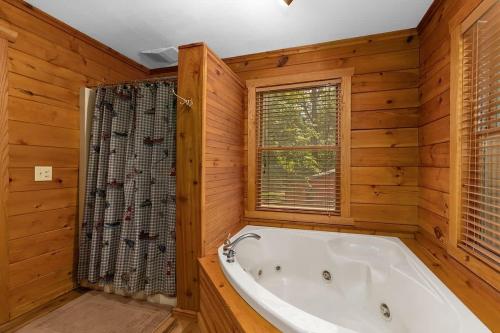 baño con bañera y ventana en Lakefront 5BR Cabin on Big Crooked Lake w Pontoon, en Rockford