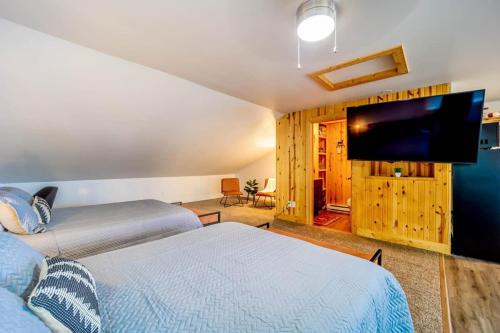 a bedroom with two beds and a flat screen tv at Fife Lake Lodge 2 Lakeside Apartment Units in One in Fife Lake