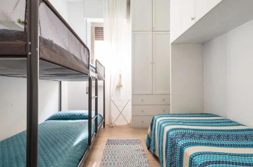 een slaapkamer met 2 bedden en een stapelbed bij [Seaside Apt] Private Parking and near the beach in Viareggio