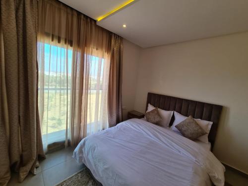 a bedroom with a bed and a large window at Appartement moderne vue sur mer in Essaouira
