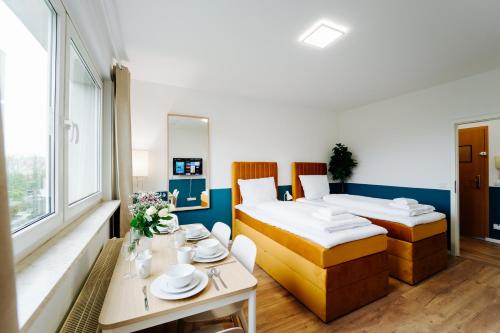 a hotel room with two beds and a table at Jenapartments for4 Boxspring & Smart TV & Waschmaschine in Jena