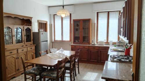 a kitchen with a table and chairs and a refrigerator at La Residenza del Cavallino in Fermo