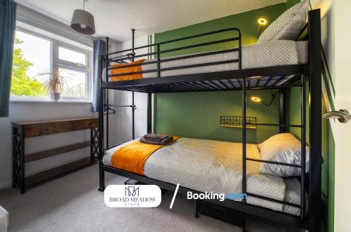 Tritton Lodge, 2 Bedroom House By Broad Meadow Stays Short Lets and Serviced Accommodation Lincoln With Free Parking في لينكولن: غرفة نوم مع سريرين بطابقين ومكتب