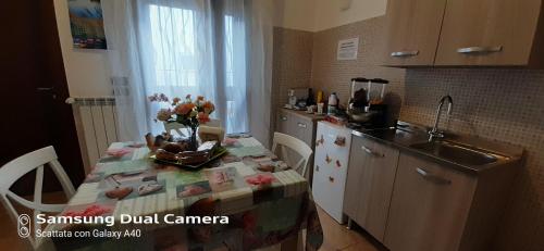 曼杜里亞的住宿－Il melograno b&b，厨房配有桌子、水槽和厨房四柱床。