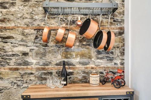 a bunch of pots and pans hanging from a brick wall at Heritage home in prime Byward Market location in Ottawa