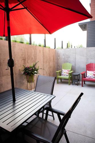 a table and chairs with a red umbrella on a patio at Modern State Unit 2 in Traverse City
