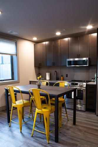 a kitchen with a table and yellow chairs in it at Modern State Unit 1 in Traverse City