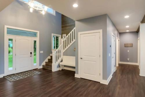 a large hallway with a white door and stairs at Bear Feet Retreat in Maple City