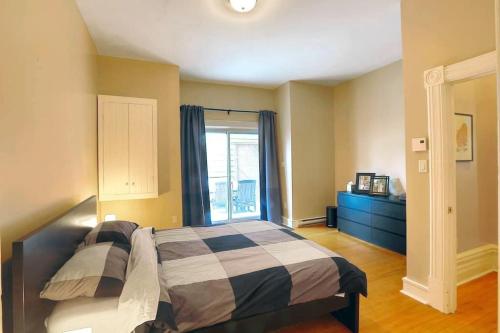 um quarto com uma cama e uma grande janela em Sunny and airy downtown apartment in Hull Gatineau em Gatineau