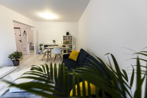 uma sala de estar com um sofá azul e uma mesa em Aparthotel West Marina em Floresti