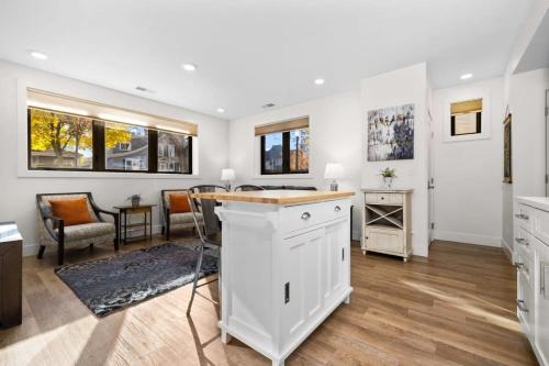 Capri Unit 001 in the Heart of Downtown TC في ترافيرس سيتي: مطبخ مع دواليب بيضاء وغرفة معيشة