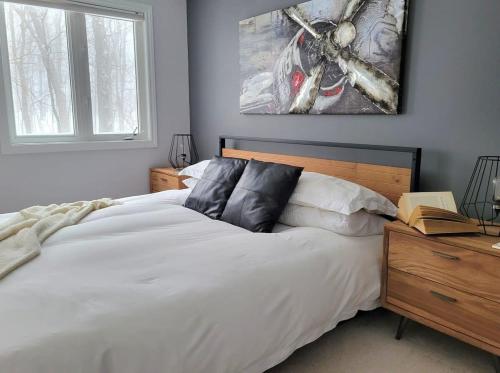 ein Schlafzimmer mit einem großen weißen Bett und einem Fenster in der Unterkunft Modern townhome in Kanata w direct forest access in Ottawa