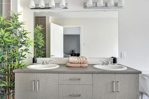 a bathroom with two sinks and a large mirror at Modern townhome in Kanata w direct forest access in Ottawa