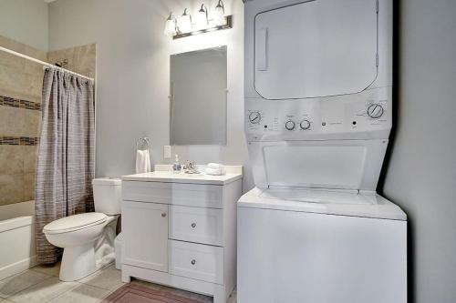 Baño blanco con lavabo y aseo en High-end condo downtown Kingston near RMC Queens en Kingston