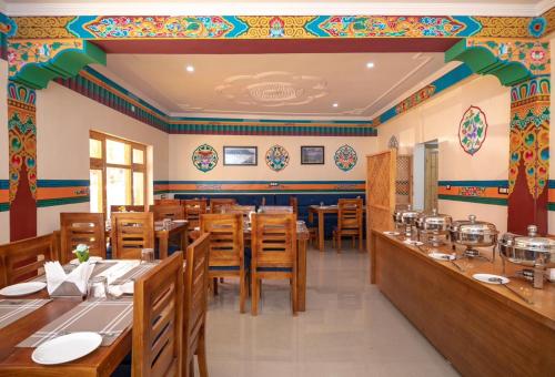 a restaurant with wooden tables and chairs and colorful walls at The Nangsay Hotel in Leh