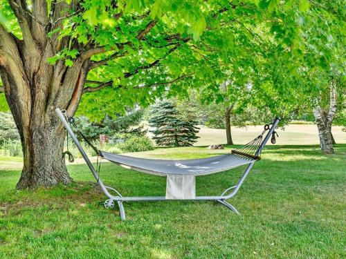 a hammock in a park next to a tree at The Gem - Beautiful farmhouse with hot tub in West Lake