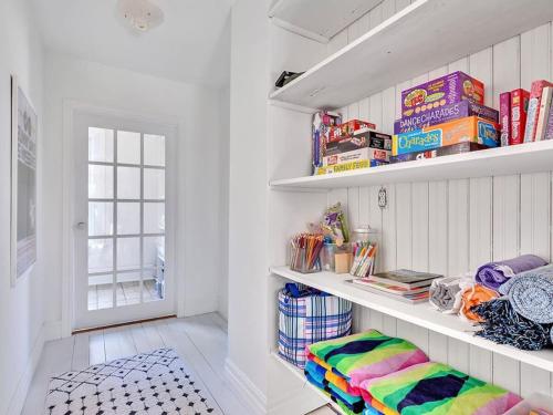 a room with white walls and shelves with books at The Gem - Beautiful farmhouse with hot tub in West Lake